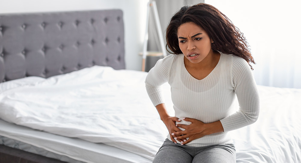 a young woman holding her side in pain due to an uti